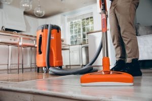 water damage restoration technician vacuuming water in house