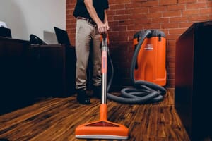 sewage backup technician vacuuming up water in office