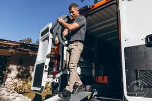 sewage backup cleanup technician taking equipment out of van